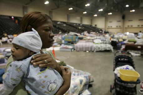 A woman carriers her grandson at a shelter for people displaced by Hurricane Katrina.