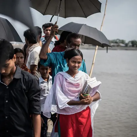 Joya Dhali (carrying books), 17, in southern Bangladesh, refused to get married at age 16.