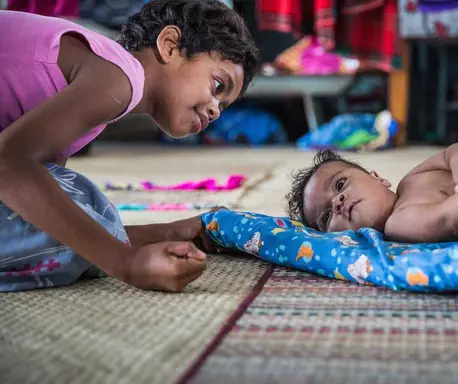 Young Child Playing with a Baby