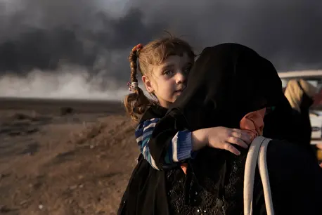 UNICEF PHOTO: A newly displaced woman carries a child at a check point in Qayyara, south of Mosul, IRAQ.