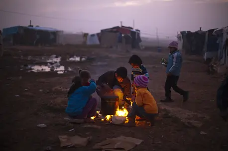 People Huddled By Fire