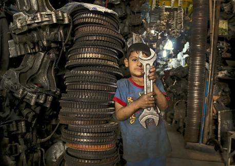 One of 3.3 million displaced Iraqis, Mustafa, 6, works with his father in an industrial area in Baghdad.