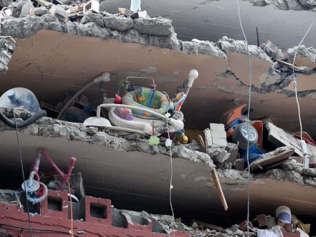 Toys and a baby walker are seen in a building flattened by the earthquake that shook Mexico City on September 18, as the search for survivors continues.