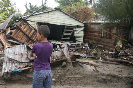 On September 7, 2017 in Boba, Nagua, a boy, 7, stands in front of debris as Hurricane Irma moves off from the northern coast of the Dominican Republic.