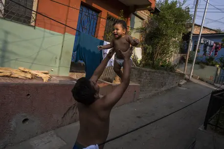 A father holds his infant son in San Salvador, El Salvador.