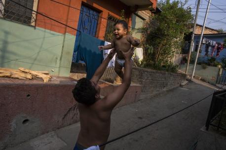 A father holds his infant son in San Salvador, El Salvador. 