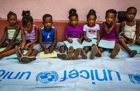 Kids Sitting With a UNICEF Banner