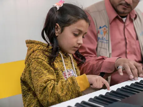 Nine-year old Nour plays the piano in the 'Musiqati' class in a UNICEF Makani Centre in Azraq Refugee Camp, Jordan. unicef, child refugees, Syrian refugees, music therapy,