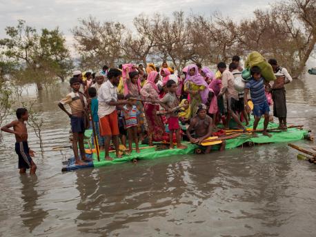 Rohingya refugees crowd onto a makeshift raft to cross the Naf River that separates Myanmar and Bangladesh, in November 2017.