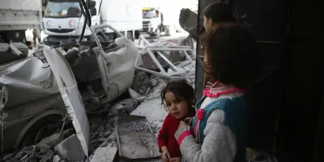 Children watch as a joint UNICEF, United Nations and Syrian Arab Red Crescent convoy of 46 trucks transporting food aid arrive in Eastern Ghouta on March 5, 2018. Children watch as a joint UNICEF, United Nations and Syrian Arab Red Crescent convoy of 46 trucks transporting food aid arrive in Eastern Ghouta on March 5, 2018.