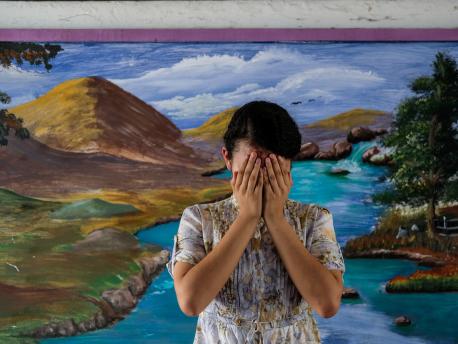 Patricia, 14, covers her face at a school in San Salvador, El Salvador. 