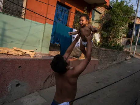 A father holds his infant son in San Salvador, El Salvador. A father holds his infant son in San Salvador, El Salvador.