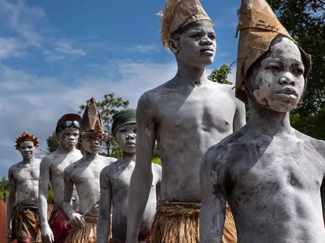 Wearing a mix of modern and traditional costumes and painted with dried cassava powder, young men and children walk to a government education ceremony in Bambari, Central African Republic on September 8, 2018. Central African Republic, UNICEF, humanitarian crisis, child protection, CAR