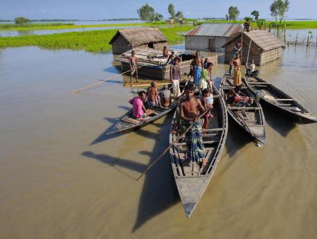 A family take to their boats after severe flooding in 2017 in the northern district of Kurigram, Bangladesh.