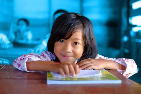 child smiling holding a book