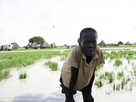 Child Leaning Over with Marsh in Background