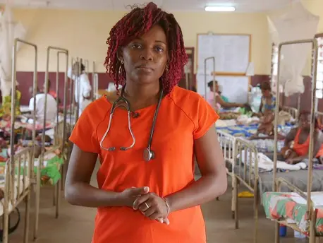 Woman Stands in Front of Room Full of Beds