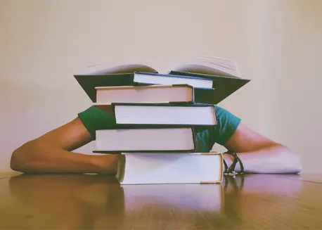 Person with Book Stacked in Front of Face