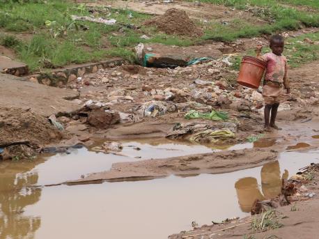 A child plays in a muddy road in the Kinama neighborhood of Bujumbura, Burundi after torrential rains flooded the region. 