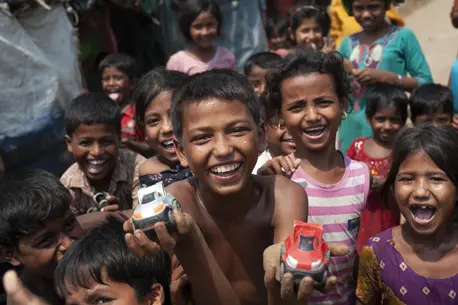 Mohammad Rifat, 12, (shirtless, center) and his friends race toy cars down a sandy stretch of trail in Shamlapur camp, Cox's Bazar District, Bangladesh on April 22 2018 Mohammad Rifat, 12, (shirtless, center) and his friends race toy cars down a sandy stretch of trail in Shamlapur camp, Cox's Bazar District, Bangladesh on April 22 2018
