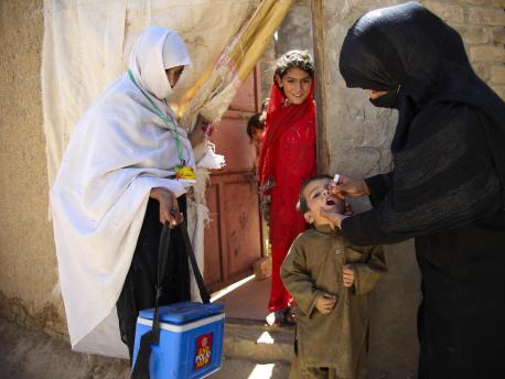A UNICEF-trained health worker vaccinates a child against polio outside the family's home in Quetta, Balochistan Province, Pakistan. 