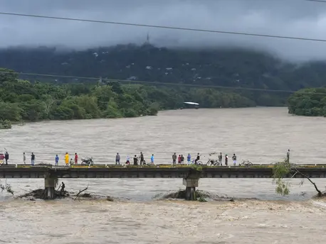 People watch the Humuya river flooding due to heavy rains caused by Eta Hurricane, in Santa Rita, Yoro department, 240 km northern Tegucigalpa, on November 3, 2020. People watch the Humuya river flooding due to heavy rains caused by Eta Hurricane, in Santa Rita, Yoro department, 240 km northern Tegucigalpa, on November 3, 2020.