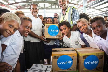 A school teacher, students of White River School in Honiara and a staff member of Red Cross holding a box with soap and other hygiene items provided to the school by UNICEF. This took place during a workshop organised by UNICEF with their partners from th