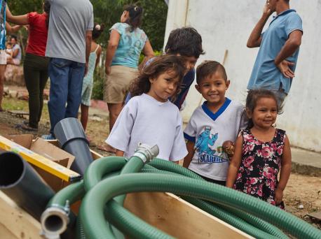 Children watch while UNICEF staff and partners install a water tank which will provide access to safe drinking water to an estimated 24,000 people a month in San Antonio, Tachira state, Venezuela.  