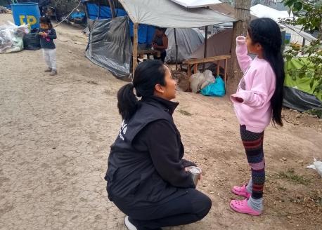UNICEF Mexico Deputy Representative Pressia Arifin-Cabo speaks with a child at an encampment in Matamoros in the northeastern state of Tamaulipas.