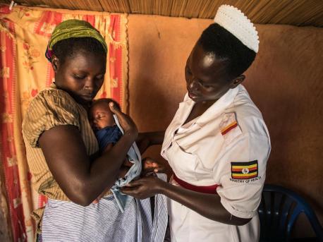 A UNICEF-trained midwife helps 28-year-old Lucy Atikoru wrap her newborn close to her body at the Omugo Health Center in Uganda on December 19, 2019.