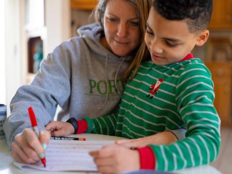 On the morning of March 16, 2020, 8-year-old second grader Luka works on a math assignment at home in Connecticut, with help from his mother, Sophia. 