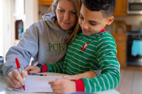 8-year-old second grader Luka works on a mathematics assignment at home in Connecticut, United States of America, with help from his mother, Sophia. Local schools were closed indefinitely effective the Friday before, 13 March, as part of precautions to co