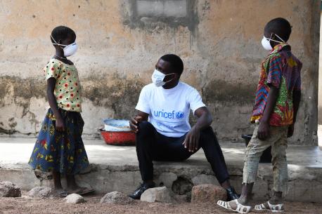In the village of Morovine, in the North of Côte d'Ivoire, a UNICEF Staff member counsels children on the importance of wearing masks or face coverings to protect themselves against the coronavirus.