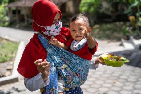 Dini feeds her year-old son Abdullah at their home in Paseban village, Central Java province, Indonesia.