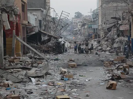 On January 19, 2010, men gather at a table and chairs set up in the middle of a street devastated by the earthquake, in Port-au-Prince, Haiti's capital. On January 19, 2010, men gather at a table and chairs set up in the middle of a street devastated by the earthquake, in Port-au-Prince, Haiti's capital.