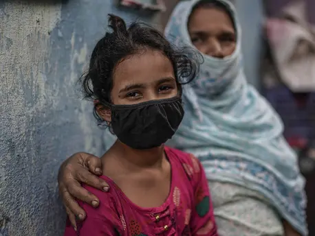 Mekak, 11, sits with her grandmother near a community toilet in the slums of Mumbai, India. UNICEF and partners are working to sustain urban slum sanitation and preparedness of schools during the COVID-19 public heatlh crisis. 