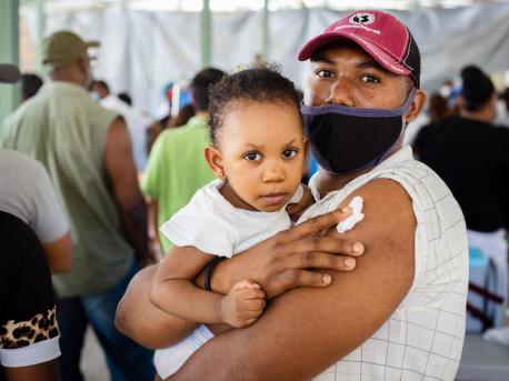 Hervé Ternier, holding his 19-month-old daughter, Rosaika, received his COVID-19 vaccine at a UNICEF-supported vaccination site in Port-au-Prince, Haiti on July 24, 2021.