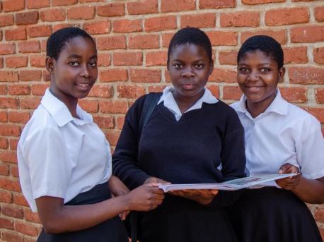 Sixteen-year-old Atupele, center, and classmates attend Salima Secondary School in central Malawi. A Kids In Need of Desks (K.I.N.D.) scholarship covers her school fees, uniform and school supplies. 