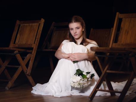 Young Girl Sitting on Floor in White Dress