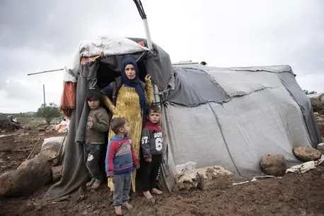 Woman with Young Children Outside Tent Entrance