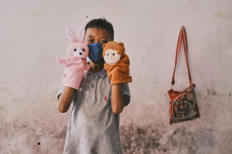 Dwi Rizky Saputra plays with toys from a recreational kit he received for children affected by COVID-19 at his home in Jombang, Indonesia, on 22 October 2020.