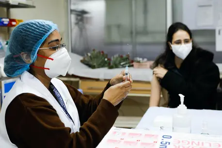 A vaccinator administers a COVID-19 vaccine to a health worker at Lok Nayak Hospital in New Delhi, India. A vaccinator administers a COVID-19 vaccine to a health worker at Lok Nayak Hospital in New Delhi, India.