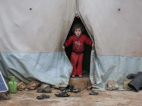On 19 January 2021, a child looks out a tent in Kafr Losin Camp in northwest Syrian Arab Republic. UNICEF is working with partners to provide displaced children in Syria with the supplies and services they need to survive and thrive. On 19 January 2021, a child looks out a tent in Kafr Losin Camp in northwest Syrian Arab Republic. UNICEF is working with partners to provide displaced children in Syria with the supplies and services they need to survive and thrive.