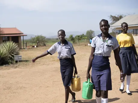 From left: 17-year-olds Margaret and Elizabeth, and Nite, 19, carry water from the newly rehabilitated borehole at Ilumum Primary School in Torit, South Sudan. From left: 17-year-olds Margaret and Elizabeth, and Nite, 19, carry water from the newly rehabilitated borehole at Ilumum Primary School in Torit, South Sudan.