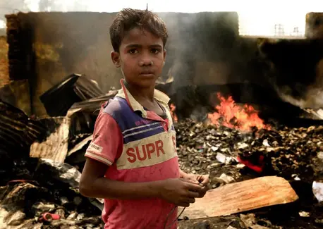 On March 23, 2021, 10-year-old Rezwan stands in the fire-damaged wreckage of the Balukhali area of the Rohingya refugee camps in Cox's Bazar, Bangladesh. On March 23, 2021, 10-year-old Rezwan stands in the fire-damaged wreckage of the Balukhali area of the Rohingya refugee camps in Cox's Bazar, Bangladesh.