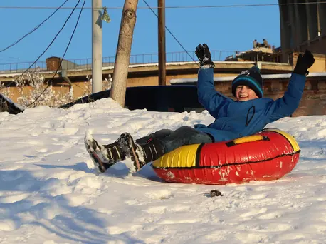 Outdoor activities are safer than indoor gatherings during the COVID-19 pandemic. In Yerevan, Armenia, a boy slides on a snow tube.
