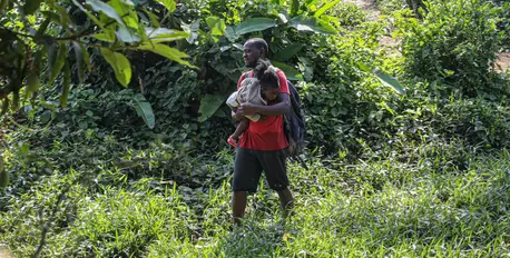 A father and child arrive exhausted after crossing the Darien Gap to Bajo Chiquito, Province of Darien, Panama. A father and child arrive exhausted after crossing the Darien Gap to Bajo Chiquito, Province of Darien, Panama.