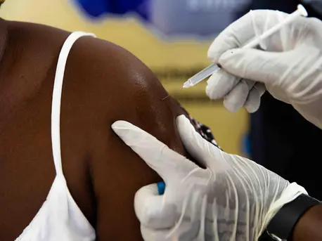 A health worker receives her COVID-19 vaccination. A health worker receives her COVID-19 vaccination.