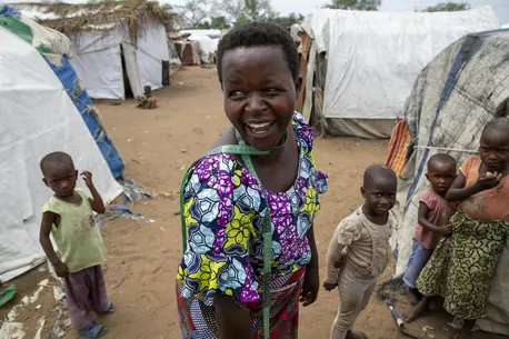 Jeannette Niyibigira, a seamstress and beneficiary of a micro-credit scheme funded by UNICEF and implemented by partner Faith in Action, greets fellow residents at a camp for internally displaced families in Gatumba, near Bujumbura, Burundi. Jeannette Niyibigira, a seamstress and beneficiary of a micro-credit scheme funded by UNICEF and implemented by partner Faith in Action, greets fellow residents at a camp for internally displaced families in Gatumba, near Bujumbura, Burundi.