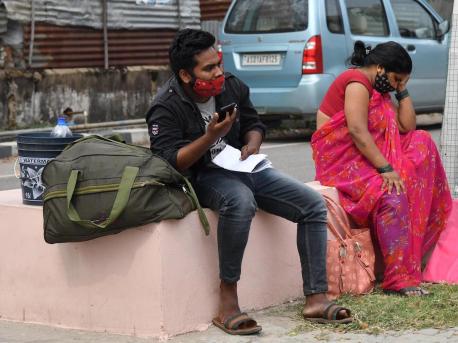COVID-19 patients sit outside the Gauhati Medical College COVID Care Hospital in Kalapahar, Guwahati, India, where all beds are full on April 30, 2021.